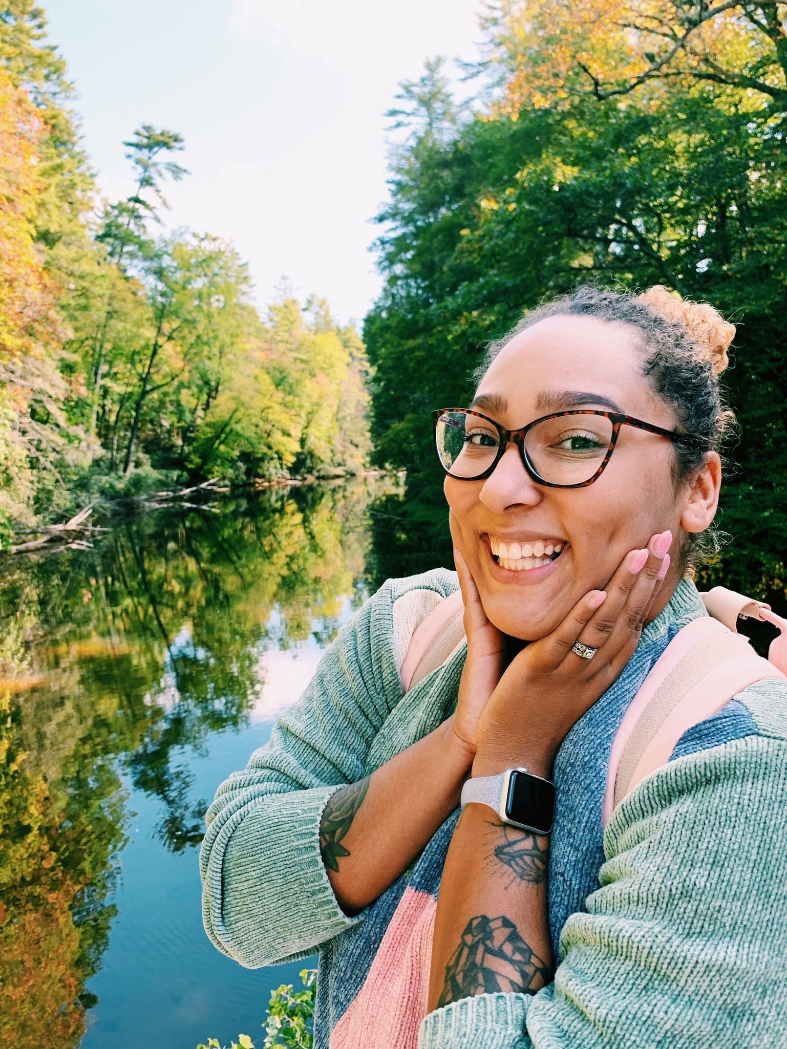 Mikayla posing for a photo in front of a river with trees on each side