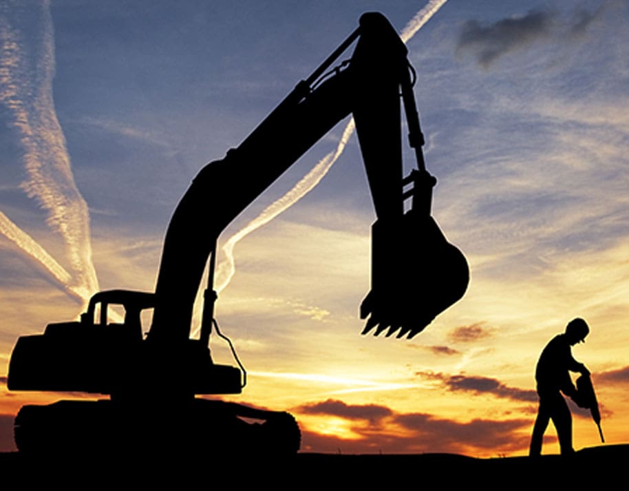 silhouette of a man holding a jack hammer next to a backhoe